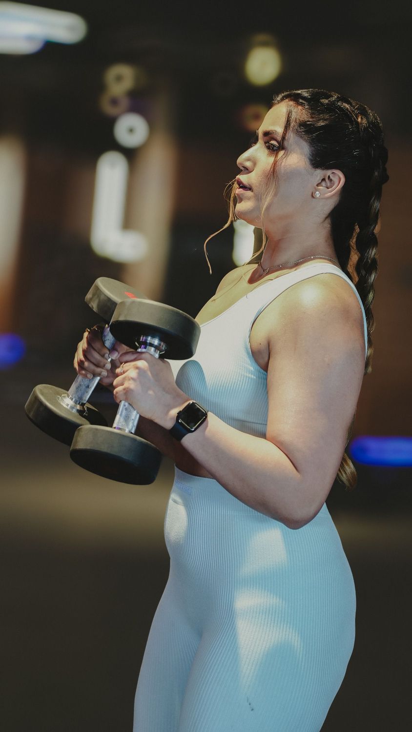 Woman holding a pair of dumbbells in front of her chest